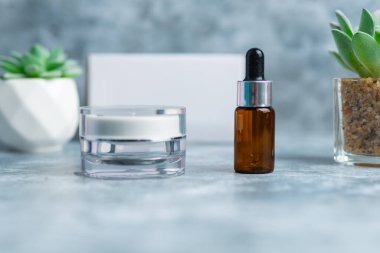 Çimento yüzeyi üzerinde koyu kahverengi serum şişesi, damlalık şişesi, güzellik, spa ve sağlık konsepti