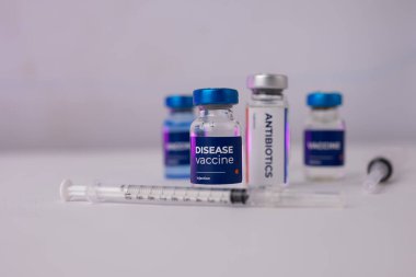 Bir masanın üzerinde duran birkaç tüp ve önlerinde küçük bir şırınga. tıbbi konsept