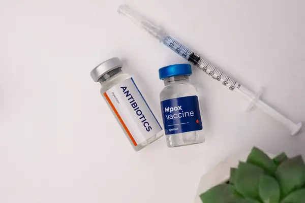Antibiyotikler, mpoks aşısı ve beyaz bir masada şırıngalar. sağlık ve tıbbi kavramlar