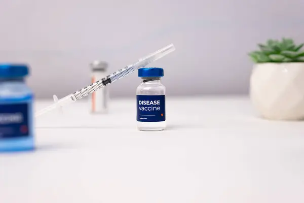 Üzerinde beyaz bir masanın üstünde şırınga olan hastalık aşısı. Sağlık ve Tıp Konsepti