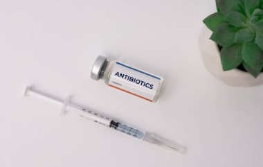 Üst köşesinde şırınga ve süs bitkisi olan bir antibiyotik. tıbbi konsept