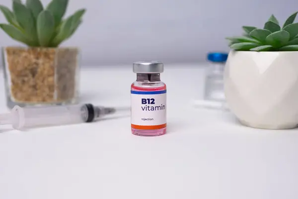 Klinik masasında şırınga olan sıvı bir B-12 vitamini. sağlık ve tıbbi kavramlar