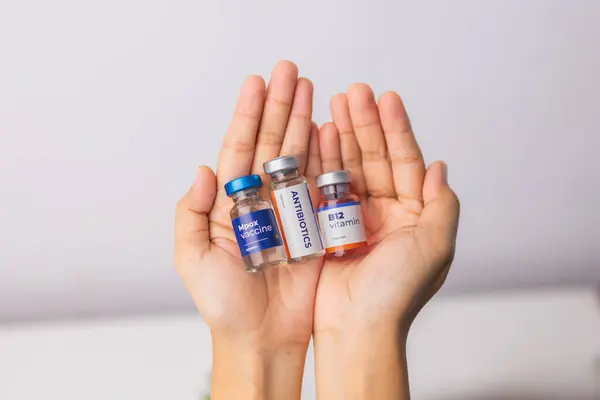 Klinikte biraz sıvı ilaç ve aşı tutan eller. sağlık ve tıbbi kavramlar.