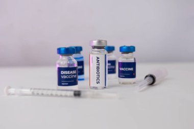 Birkaç aşı ve bir klinik odasındaki masanın üzerinde süs çiçekleri olan bir şırınga. sağlık ve tıbbi kavramlar