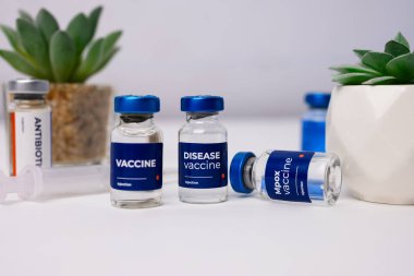 Tıbbi klinikteki bir masada yapay çiçekli aşılar. sağlık ve tıbbi kavramlar