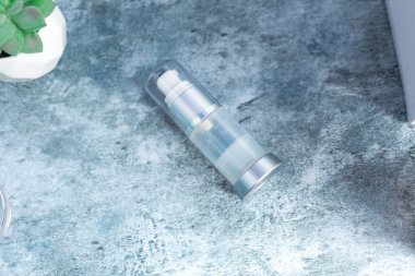 Çimento yüzeyinde saydam sprey şişesi, güneş kremi, güzellik konsepti.