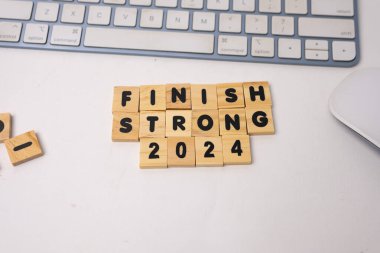 the wooden box says finish strong 2024 on top of white desk clipart