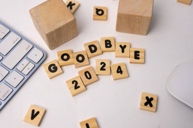Ahşap kutu 2024 'e veda ediyor. Beyaz masanın üstünde, etrafında tahta kutular var.