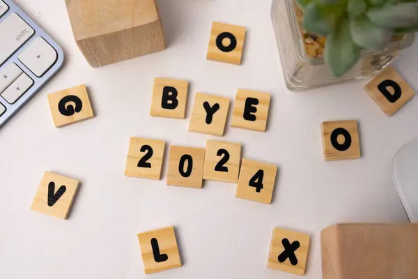 Ahşap kutuda 2024 yazıyor. Etrafında tahta kutular var.