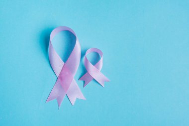 Mavi arka planda pembe kurdeleler. Kanser kurdeleleri, kanser geçmişi