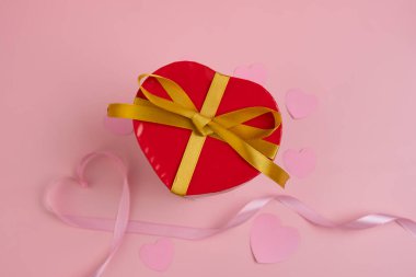 A heart shaped gift box with a gold ribbon. valentine background concept clipart