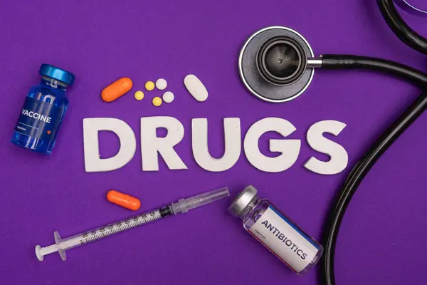 Aşılar, antibiyotik hapları şırınga ve uyuşturucu kelimesinin etrafını saran steteskop. sağlık ve tıbbi kavram geçmişi