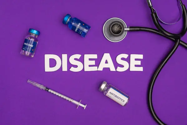 Aşı antibiyotikleri bir şırınga ve hastalık kelimesini çevreleyen bir steteskop. Hastalık farkındalığı kavramı