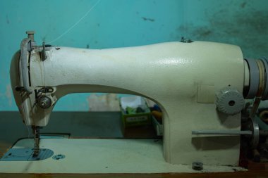 Dikiş makinesi iplik ve eski dikiş makinesiyle boş boş oturur.