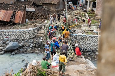 mutual cooperation to build a makeshift bridge by residents, a bridge that collapsed after heavy flooding in situbondo, east java, indonesia, february 5, 2025 clipart