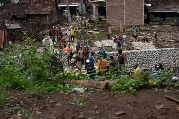 Yerleşimciler tarafından geçici bir köprü inşa edilmesi, Doğu Java, Endonezya, 5 Şubat 2025 'teki sel felaketinin ardından yıkılan bir köprü.