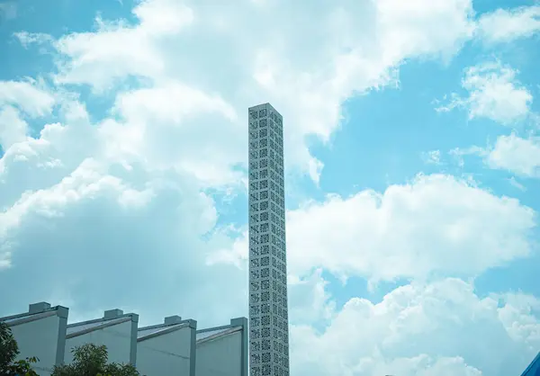 Bulutlu bir gökyüzüne karşı duran yüksek bir bina.