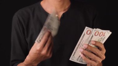 Bir adam elinde birkaç dolarlık banknotlar tutarken parasını yelpazeliyor. iş ve finans kavramı
