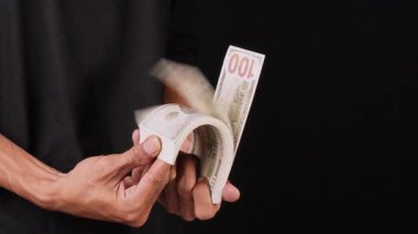 Adamın biri bir sürü para saçıyor. Adamın eli para tutuyor ve onlara gösteriyor.