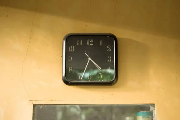 Duvarda asılı olan saat öğleden sonra beş buçuğu gösteriyor.