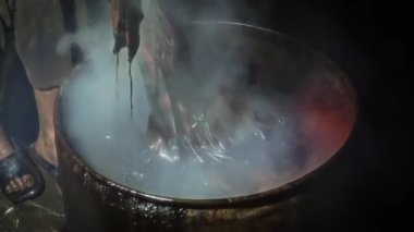 Balmumunu temizlemek için sıcak su ve soda külü ile haşlanmış batik. Geleneksel Endonezya batiği yapma süreci