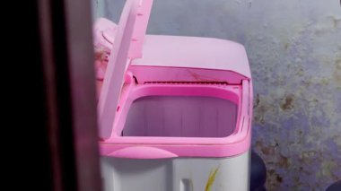 Kirli çamaşırları çamaşır makinesine koyan bir el.