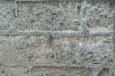 Soyulmuş tuğlanın dokusu, çakıl, kaba kum ve çimentodan oluşan tuğlanın bileşimini gösteriyor..