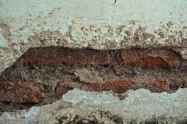 Altta yatan tuğla duvarı ortaya çıkaran bir alçı duvar. Kırık duvarın dokusu