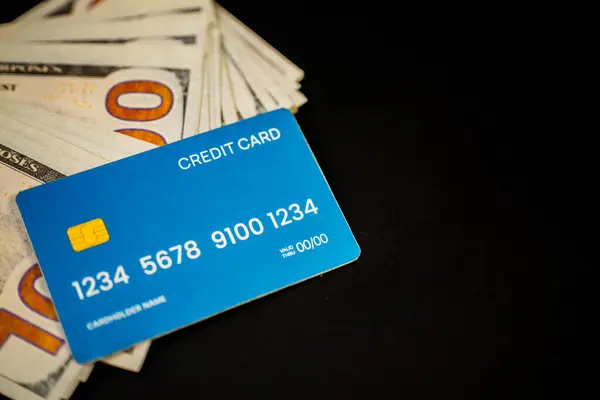 Bir yığın banknotun üstüne yerleştirilmiş bir kredi kartı. Bu görüntü bir iş ve finansal kopyalama alanı kavramıdır..