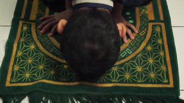 Bir çocuk secdeye kapanıyor, tanrısına dua ediyor, kendini tanrıya adıyor.