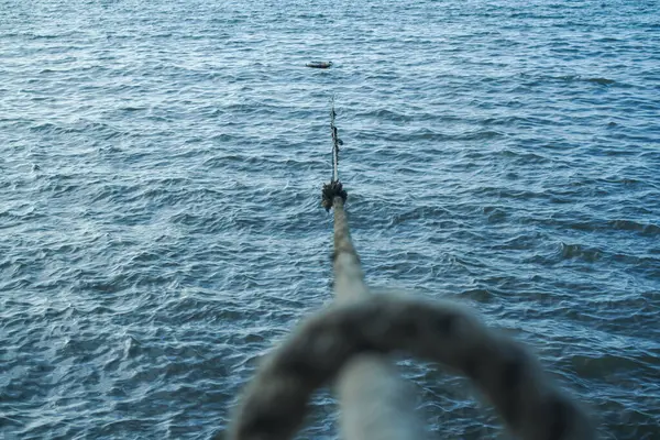 Dalgalı su üzerinde lider bir çizgi oluşturan bir ip.