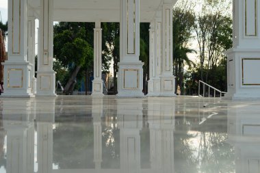 Birkaç kare sütun, zemindeki yansımalarla gücü betimler.