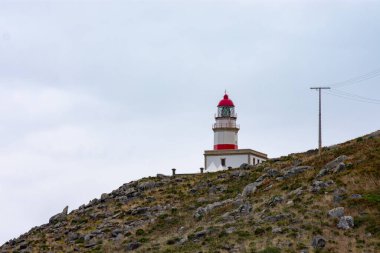 Cabo Silleiro deniz feneri. Kayalık dağ rehberlerinde kırmızı çizgileri olan denizciler.