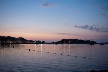 Baiona alacakaranlıkta evleriyle, deniziyle ve arka planında Monterreal kalesiyle Santa Marta 'dan görüldü.