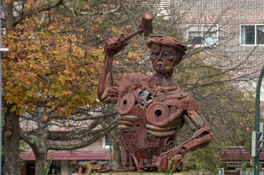 Vigo, Pontevedra, İspanya; 18 Aralık 2022; Metal işçisine hürmet, metal parçalarından yapılmış bir işçinin bir parçaya çarpması