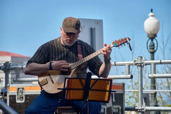 stock image Vigo, Pontevedra, Spain; April 7, 2024; A member of a band plays the mandolin at the festivals of the Reconquista of Vigo