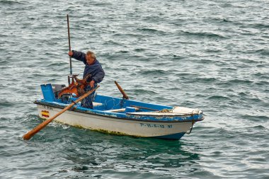 Mavi tulumlu bahriyeli az önce bir ahtapot yakalamış.