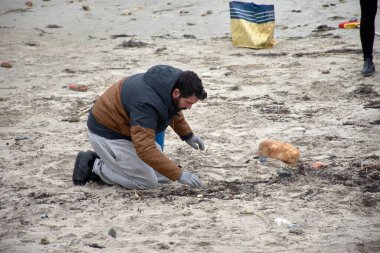 Nigran, İspanya; Ocak 09.2024; Çok sayıda gönüllü, huni, süzgeç, eldiven gibi temel araçlar kullanarak bir tekneye düşen plastik topakları toplamak için Galiçya plajlarına gitti.