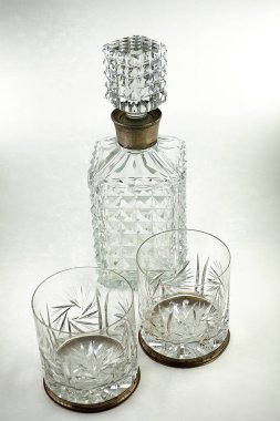 Kristal sürahi ve iki tane oyulmuş cam sürahiyi budamada ve bardakların kenarında gümüş süsleme ile kes.