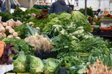 Pırasalı sebze tezgahı, lahana yeşili, marul, pancar, şalgam yeşili, İsviçre pazarı, kereviz, tatlı patates, lahana, Portekiz 'deki Barcelos fuarında.