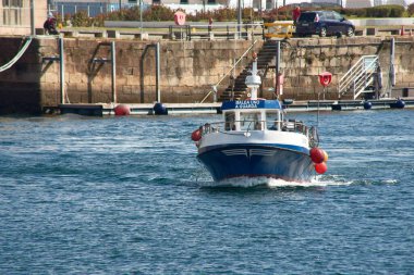 Vigo, Pontevedra, İspanya; 29 Haziran 2021; yan taraftaki şamandıralarla birlikte küçük mavi balıkçı teknesi limana varır ve adı Balea uno 'dur.