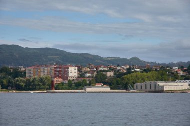 İspanya 'nın Vigo şehrinde, arka planda paslı deniz feneri ve dağlarıyla Ria' dan Deniz Müzesi 'ne manzara