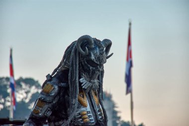 Baiona, Pontevedra, Galicia, İspanya, Mart 04.2023; Arka planda bayrakları olan demir yırtıcısını taklit eden insan heykeli