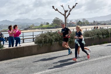 Baiona, Pontevedra, Galicia, İspanya; 26 Mart 2023; Vigo 'dan Baiona' ya, VigBay 'e giden popüler yarışın çok yorgun koşucularını halk alkışlıyor.