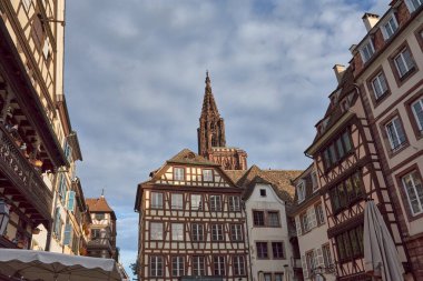 Gotik ön cephe, ana kapı ve Fransa 'nın Strazburg kentindeki geleneksel yarı ahşap evler boyunca görülen Notre Dame Katedrali' nin gül penceresi.