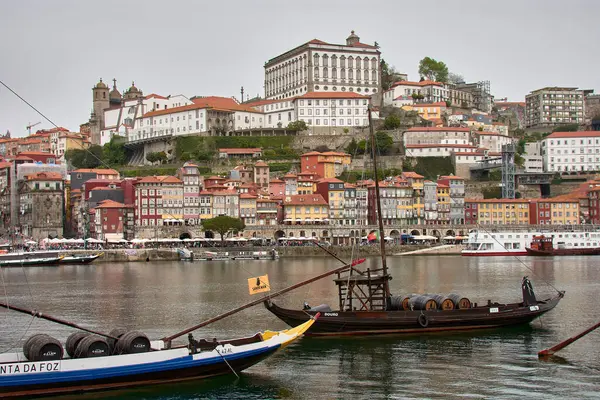 Porto, Portekiz - Mart 28,2022: Porto, geleneksel Rabelo tekneleriyle Douro nehri üzerindeki eski Portekiz kasabası. Eski mahalle ve onun su kenarındaki tipik renkli evleri