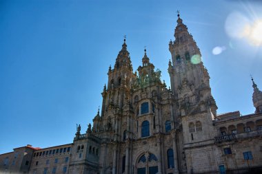 Bu etkileyici görüntü Santiago de Compostela Katedrali 'nin ihtişamını tarihi Plaza del Obradoiro' dan yansıtıyor. Kulelerinden birinin üzerindeki güneşin parlaklığı anıtın mimari güzelliğini ve ruhani ihtişamını arttırır.