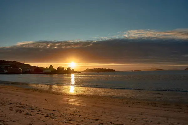 stock image Serene beauty of a sunset at Ladeira Beach in Sabaris. Soft clouds cross the horizon, adding a touch of elegance to the scene. The calm waters reflect the vibrant colors, creating a fascinating spectacle.