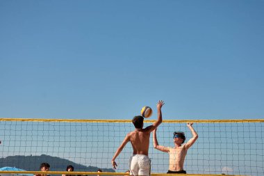 Baiona 'da düzenlenen 3x3 Ladeira Plaj Voleybol Turnuvası' nda oyuncular kollarını kaldırıp ağda güçlü bir blok oluşturdular. Sahne, plaj voleybolunda gerekli rekabet ruhunu ve takım çalışmasını yakalıyor..