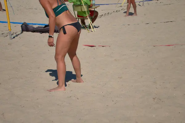 stock image A beach volleyball player in the 3x3 Ladeira Tournament at Baiona stands poised and tense, ready to receive the serve. Her focused expression and athletic stance capture the anticipation and intensity of the moment.